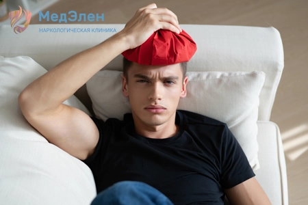 Мужчина лежит на диване, прикладывает к голове компресс